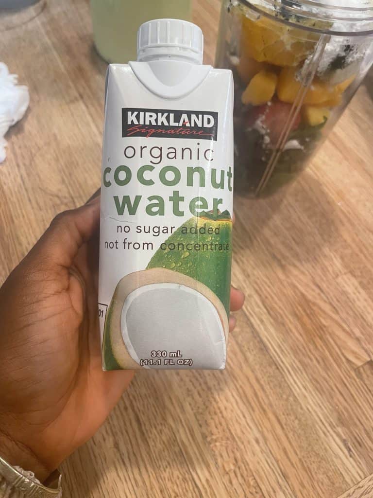 a hand holding a carton of coconut water