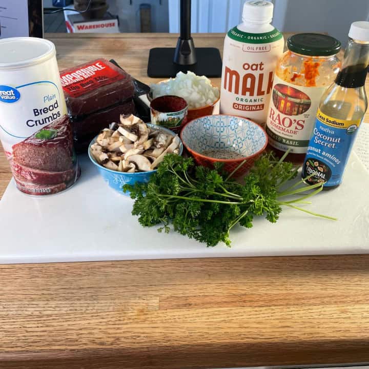 showing of the ingredients needed to prepare the vegan meatloaf (breadcrumbs, impossible meat, mushrooms, parsley, plant milk, spices, tomato sauce, coco aminos...)