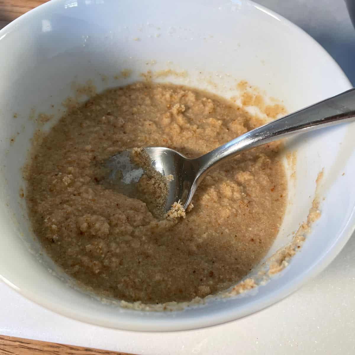 white bowl showing the result binder made of breadcrumbs mixed with almond milk