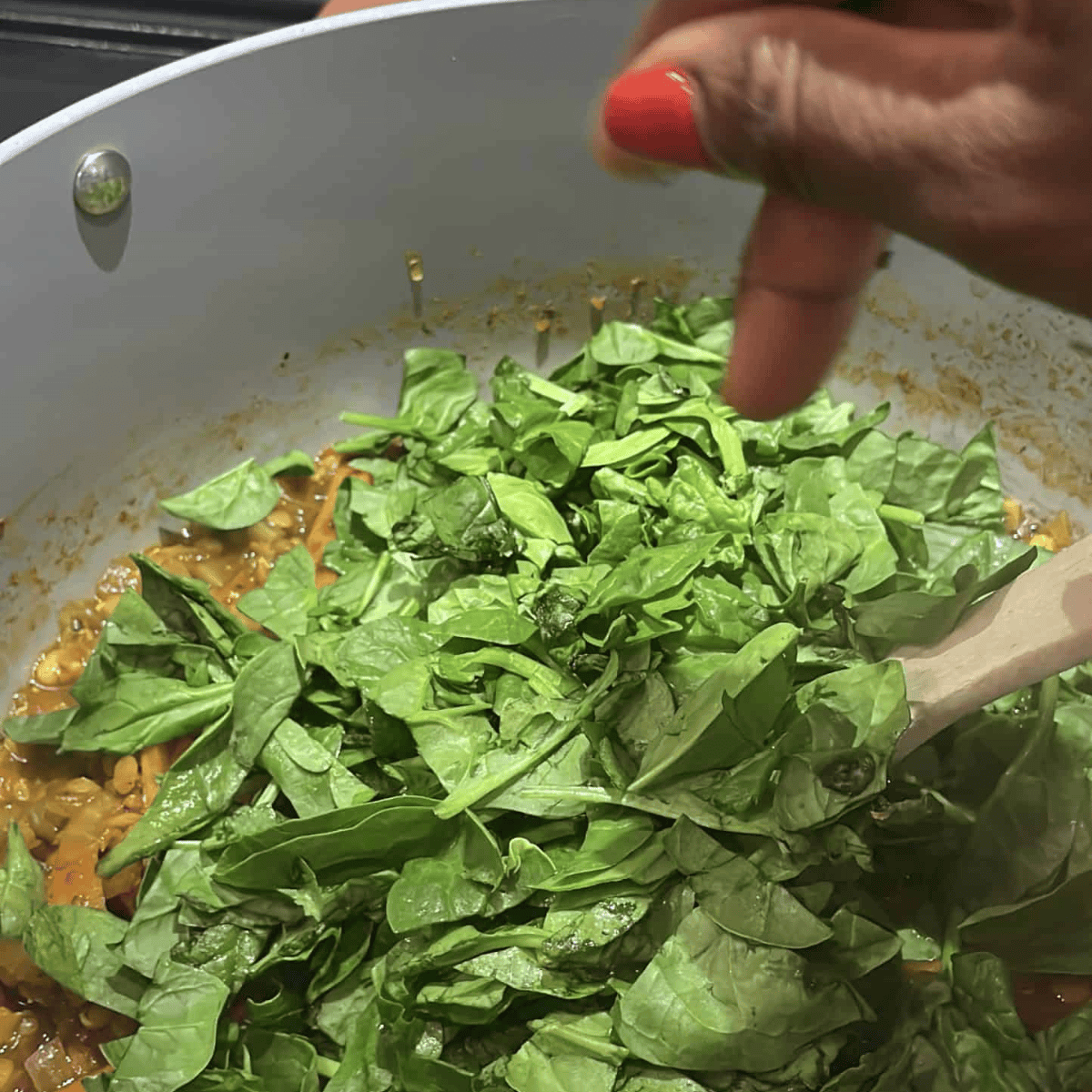 add greens to the pot for the mung dal lentil curry soup