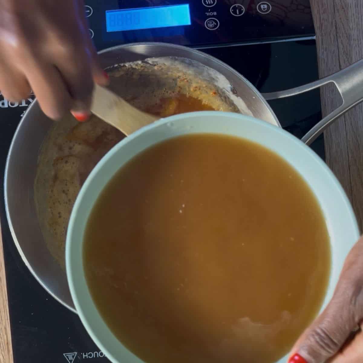 bowl of broth mixed ready to be added to the flour + butter + tomato paste in a casserole behind