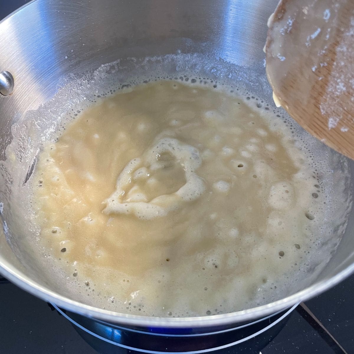 pot with melted butter and flour cooking together to make the roux for the gravy
