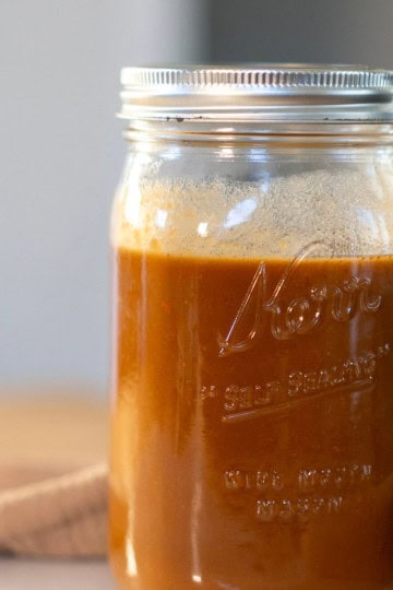 Creamy, golden brow vegan gravy in a glass jar