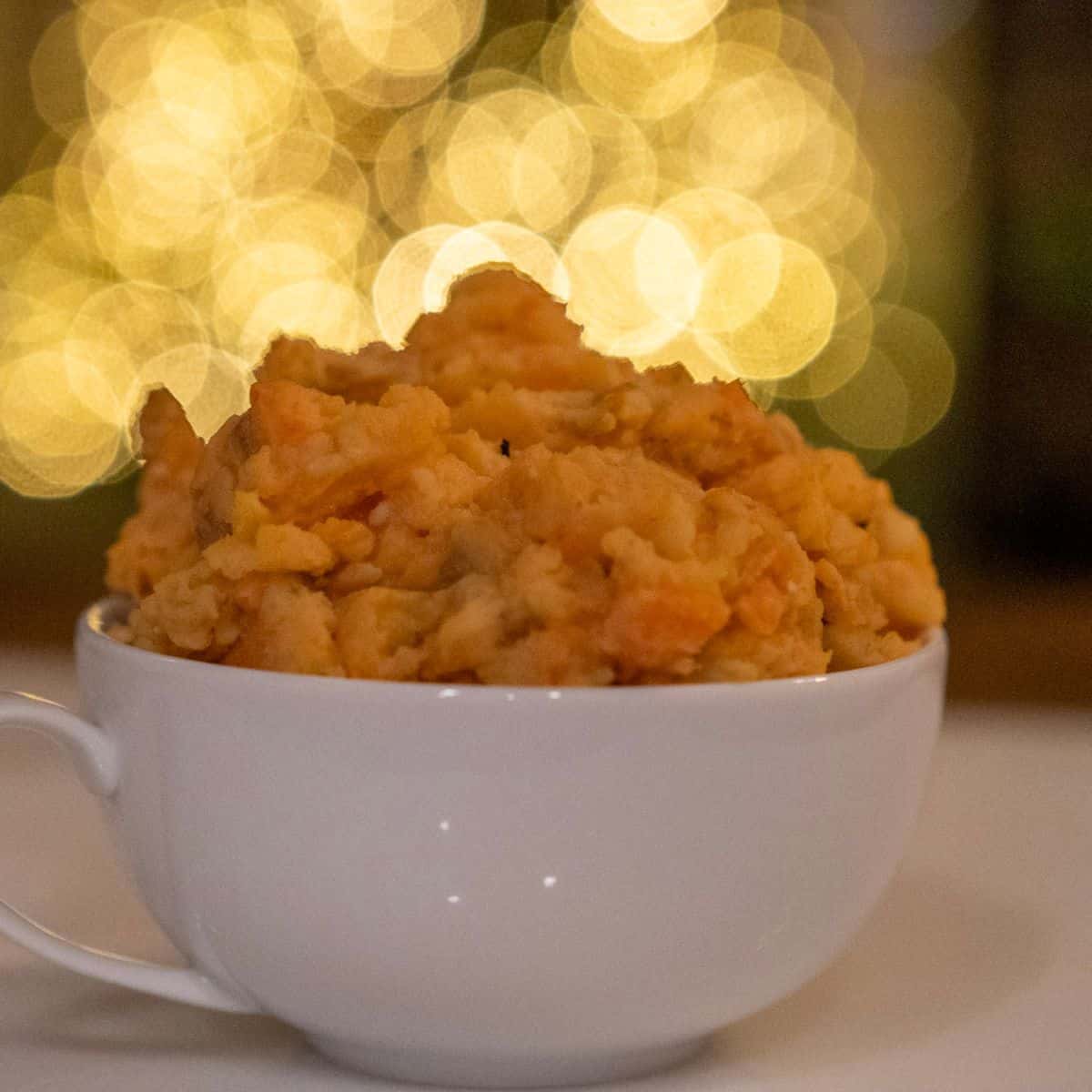 Delicious low calorie mashed potatoes served in a white cup, perfect for holiday gatherings and comfort food.