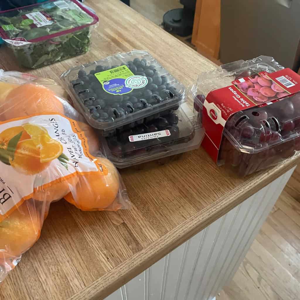 Fresh organic blueberries and cherries on a wooden kitchen countertop.