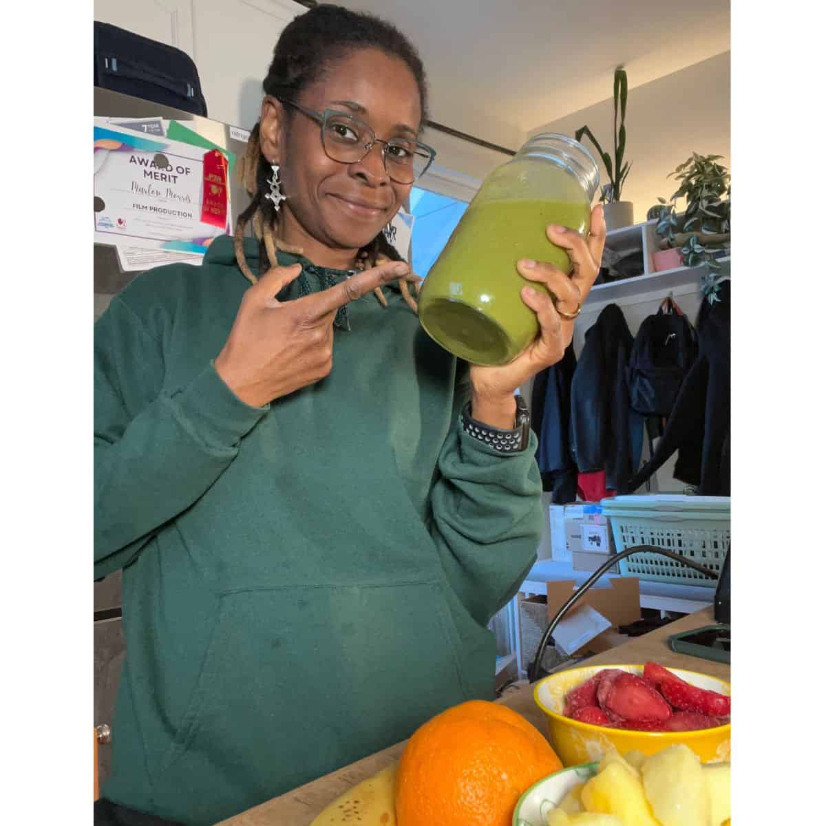 Woman holding a green smoothie in a jar, promoting digestion-friendly morning drinks.